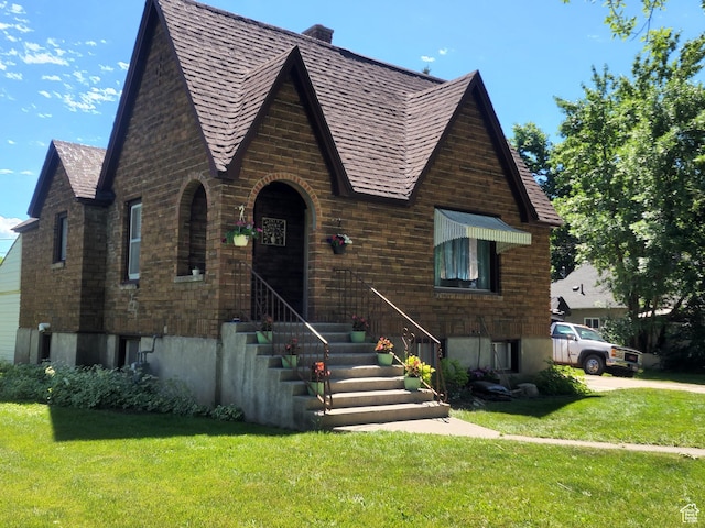 tudor-style house featuring a front lawn
