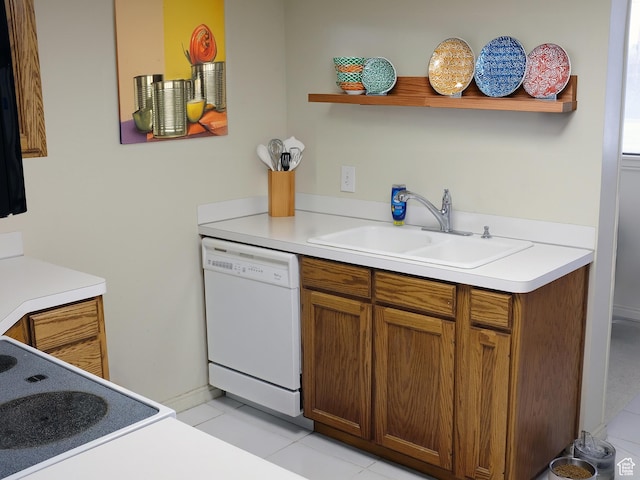 kitchen featuring dishwasher, sink, light tile patterned flooring, and range