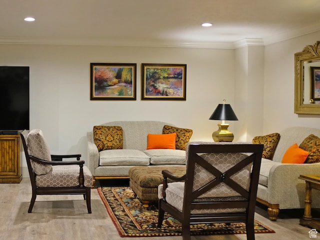 living room with crown molding and light hardwood / wood-style flooring