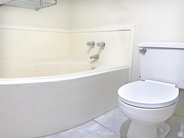 bathroom with tile patterned flooring, a bathtub, and toilet