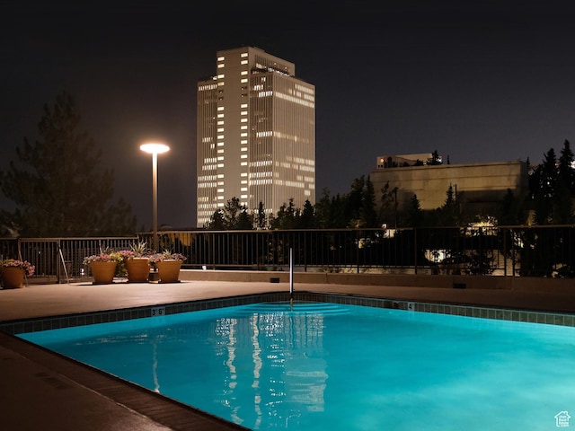 view of pool at twilight