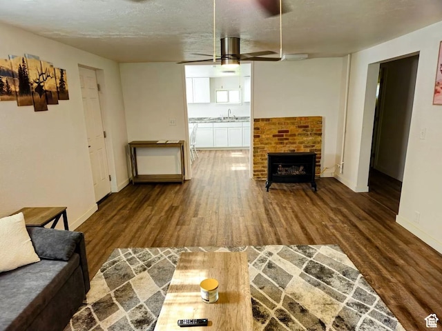 928 Monroe St, Montpelier, ID 83254 - living room featuring ceiling fan, sink, hardwood / wood-style floors, and a brick fireplace