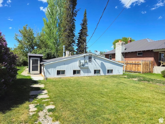 rear view of property featuring a lawn