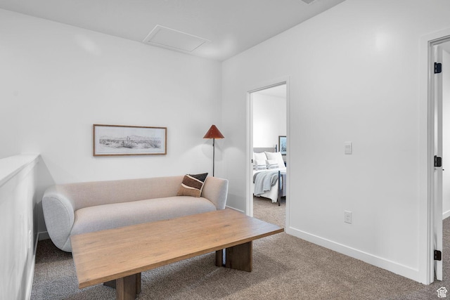 sitting room with carpet flooring, baseboards, and attic access