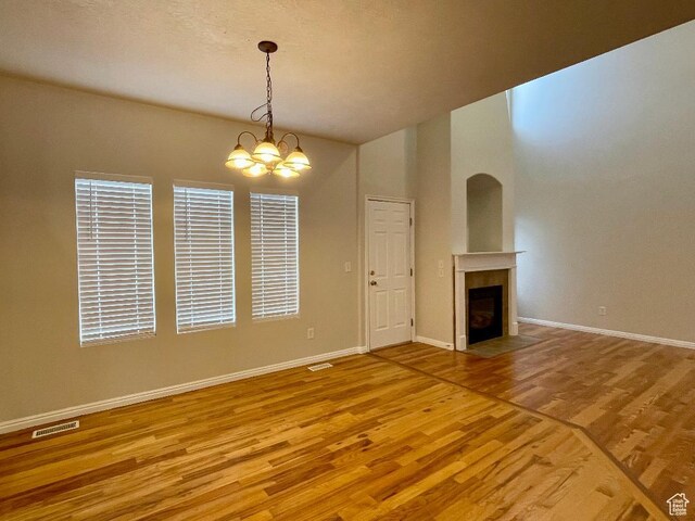 909 E Rosebud Ct, Draper, UT 84020 - unfurnished living room with wood-type flooring and an inviting chandelier