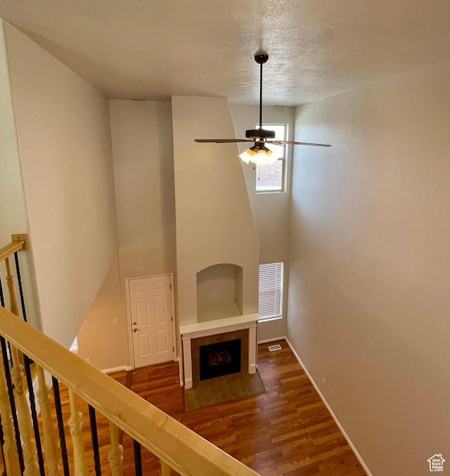 909 E Rosebud Ct, Draper, UT 84020 - unfurnished living room featuring a tile fireplace, dark wood-type flooring, a textured ceiling, and ceiling fan