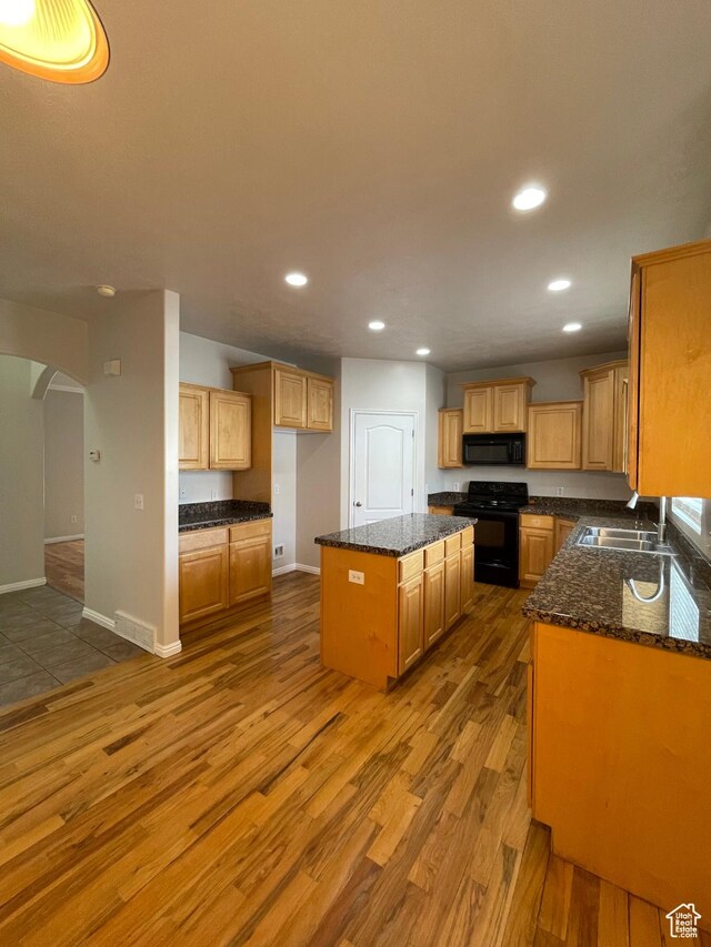 909 E Rosebud Ct, Draper, UT 84020 - kitchen with sink, dark stone countertops, wood-type flooring, black appliances, and a kitchen island