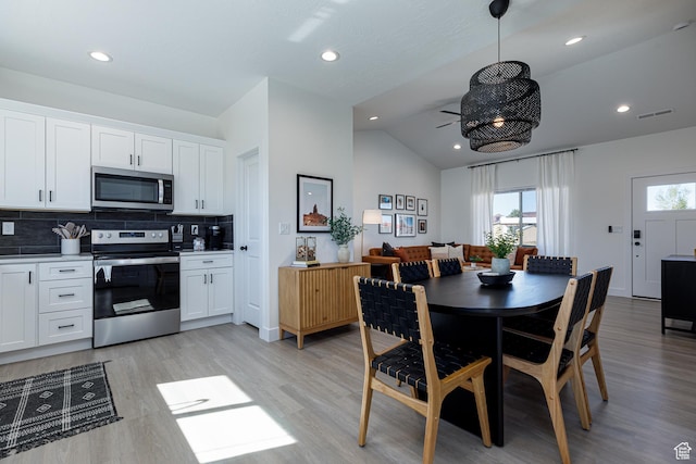dining space featuring vaulted ceiling, visible vents, recessed lighting, and light wood-style floors