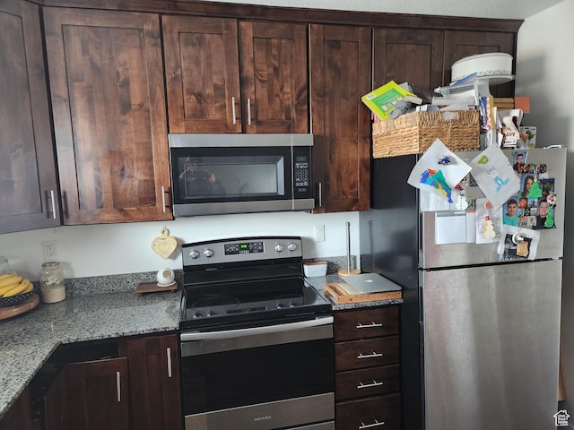 605 N Kay Ln, Tooele, UT 84074 - kitchen featuring stainless steel appliances, light stone countertops, and dark brown cabinetry