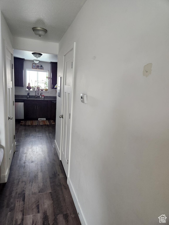 605 N Kay Ln, Tooele, UT 84074 - hallway featuring dark wood-type flooring, sink, and a textured ceiling