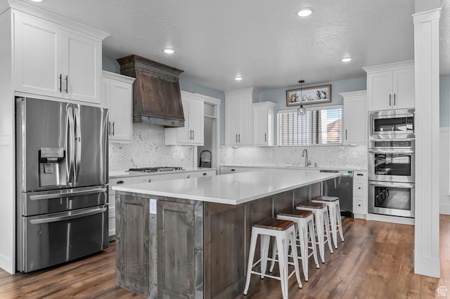 1426 S 1450 W, Mapleton, UT 84664 - kitchen with dark wood finished floors, a kitchen island, custom range hood, stainless steel appliances, and white cabinetry