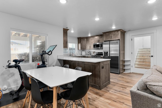 1426 S 1450 W, Mapleton, UT 84664 - kitchen featuring appliances with stainless steel finishes, light wood-type flooring, dark brown cabinetry, and a peninsula