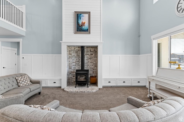 1426 S 1450 W, Mapleton, UT 84664 - living room featuring a wood stove, a towering ceiling, a decorative wall, and carpet flooring