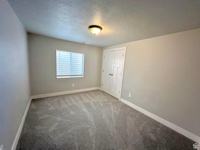 545 E Petersen Pkwy, South Weber, UT 84405 - unfurnished bedroom with a textured ceiling, a closet, carpet flooring, and baseboards