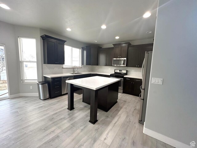 545 E Petersen Pkwy, South Weber, UT 84405 - kitchen featuring a kitchen island, a sink, stainless steel appliances, light countertops, and backsplash