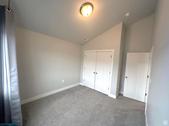 545 E Petersen Pkwy, South Weber, UT 84405 - unfurnished bedroom featuring visible vents, baseboards, vaulted ceiling, a closet, and dark colored carpet
