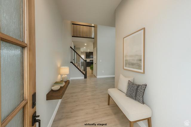 545 E Petersen Pkwy, South Weber, UT 84405 - hallway featuring stairway, wood finished floors, a towering ceiling, and baseboards