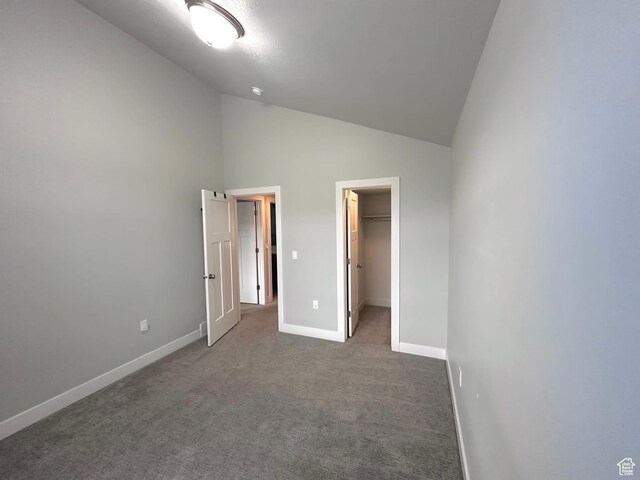 545 E Petersen Pkwy, South Weber, UT 84405 - unfurnished bedroom featuring high vaulted ceiling, baseboards, a spacious closet, a closet, and dark colored carpet