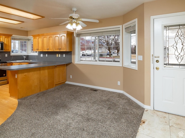 kitchen with stainless steel appliances, kitchen peninsula, and ceiling fan