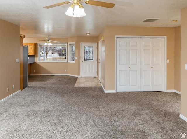 unfurnished living room with light colored carpet and ceiling fan