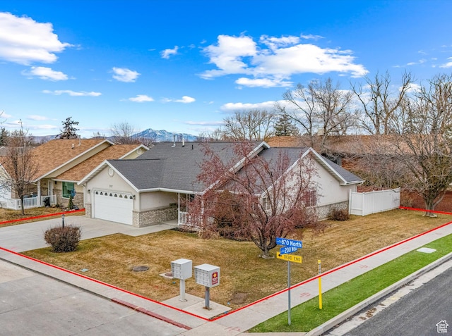 single story home with a mountain view, a garage, and a front yard
