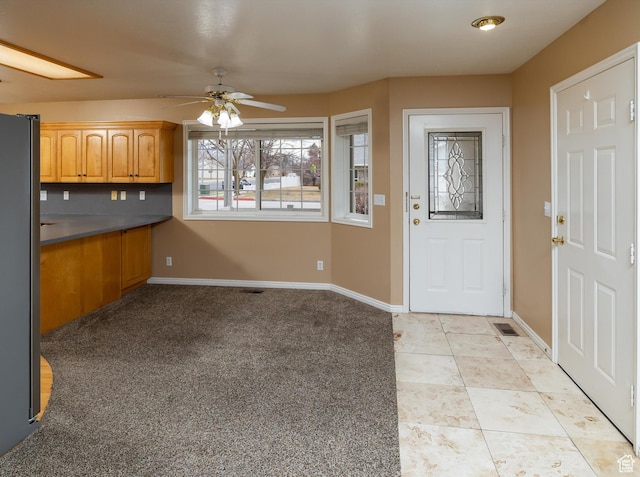 kitchen featuring stainless steel refrigerator, ceiling fan, and light tile patterned floors