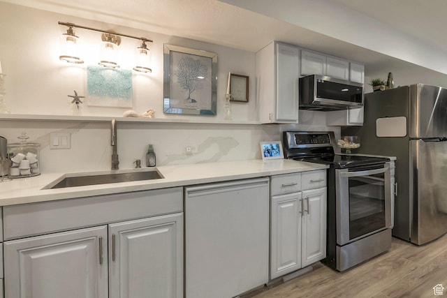 14139 S Radial Ln, Draper, UT 84020 - kitchen featuring appliances with stainless steel finishes, a sink, light wood-style floors, and light countertops