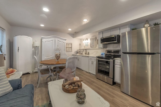 14139 S Radial Ln, Draper, UT 84020 - kitchen with stainless steel appliances, light countertops, recessed lighting, light wood finished floors, and a sink