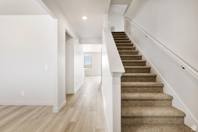stairway with wood finished floors, recessed lighting, and baseboards