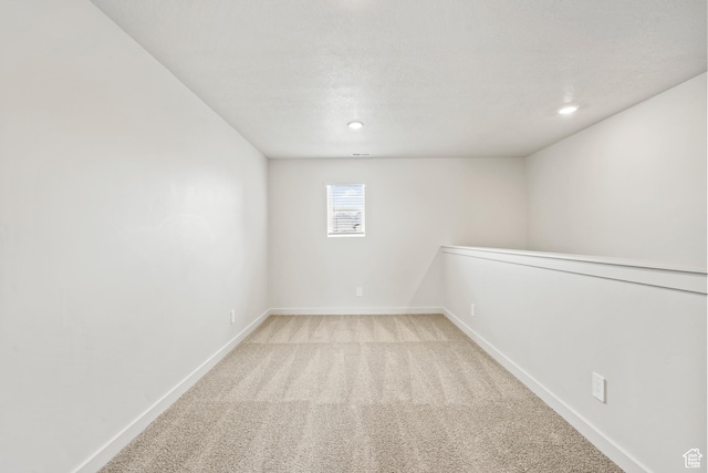 basement featuring baseboards, light colored carpet, and recessed lighting
