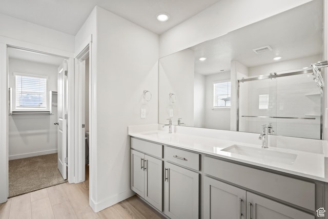 bathroom with a shower stall, plenty of natural light, double vanity, baseboards, and recessed lighting