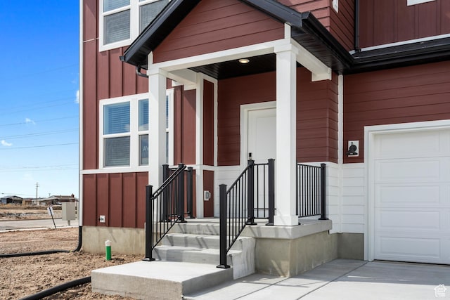 property entrance featuring board and batten siding, a garage, and concrete driveway