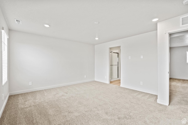 empty room with light colored carpet, recessed lighting, baseboards, and plenty of natural light