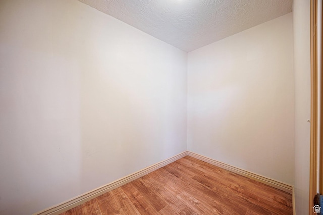 unfurnished room with wood-type flooring and a textured ceiling