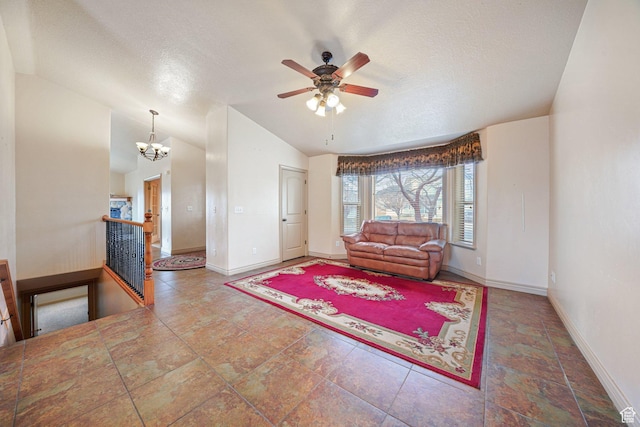 living room featuring lofted ceiling, ceiling fan with notable chandelier, and a textured ceiling