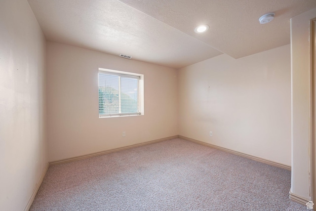 empty room featuring carpet and a textured ceiling