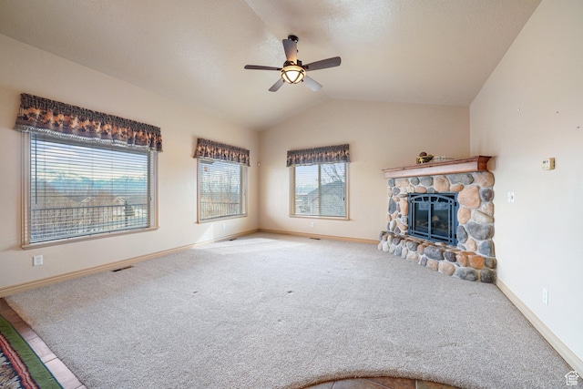 unfurnished living room with a fireplace, lofted ceiling, carpet, ceiling fan, and a textured ceiling
