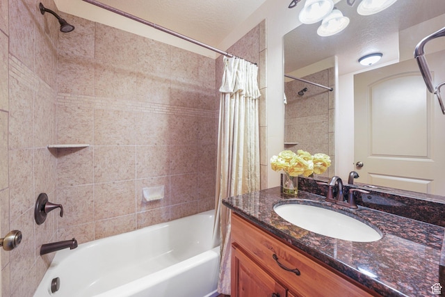bathroom featuring shower / bath combo with shower curtain, vanity, and a textured ceiling