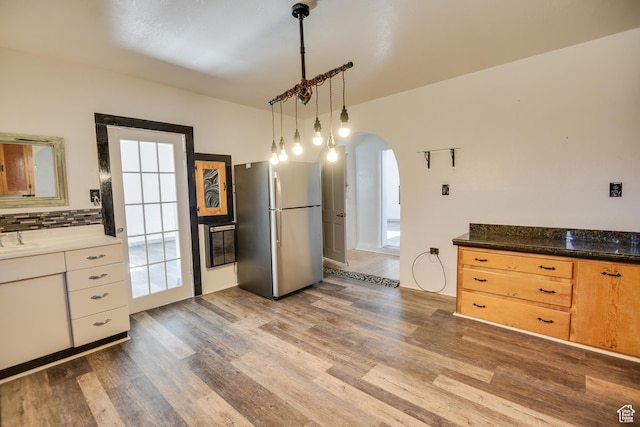 kitchen with sink, stainless steel refrigerator, dark hardwood / wood-style floors, tasteful backsplash, and decorative light fixtures