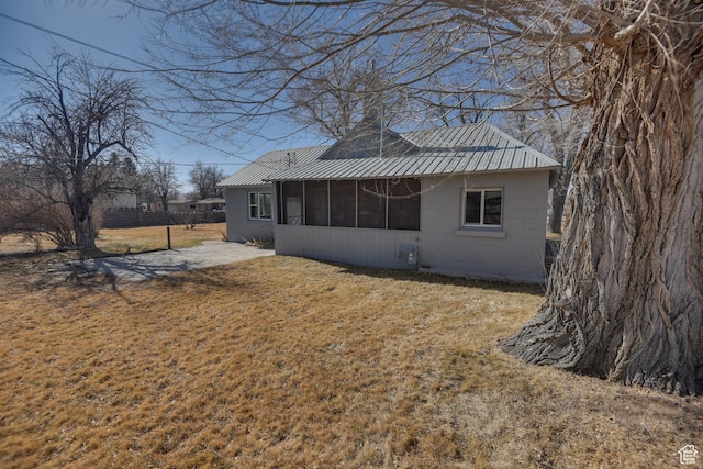 rear view of house featuring a yard and a sunroom