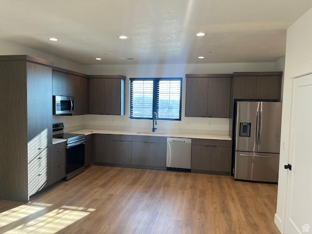 10131 N Redwood, Cedar Hills, UT 84062 - kitchen with dark brown cabinetry, stainless steel appliances, sink, and light hardwood / wood-style flooring
