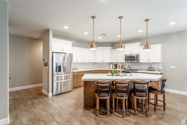 3274 W 2530 S, Hurricane, UT 84737 - kitchen with stainless steel appliances, hanging light fixtures, a center island with sink, and white cabinets