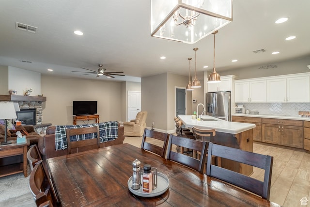3274 W 2530 S, Hurricane, UT 84737 - dining space featuring sink, light hardwood / wood-style flooring, a fireplace, and ceiling fan