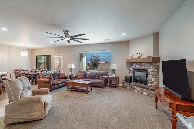 3274 W 2530 S, Hurricane, UT 84737 - carpeted living room featuring ceiling fan, a stone fireplace, and a textured ceiling