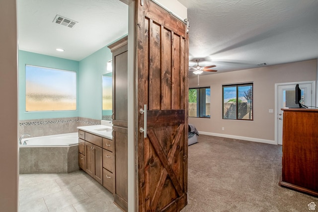 3274 W 2530 S, Hurricane, UT 84737 - bathroom featuring vanity, ceiling fan, tiled bath, and a textured ceiling
