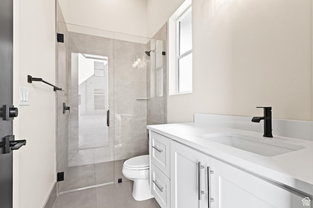 bathroom featuring vanity, tile patterned flooring, toilet, and walk in shower