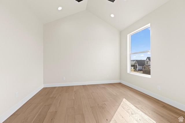 unfurnished room with vaulted ceiling and light wood-type flooring