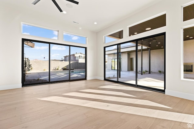 spare room featuring a towering ceiling and light wood-type flooring