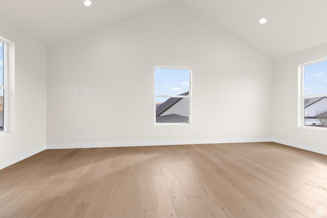 spare room featuring high vaulted ceiling and light wood-type flooring