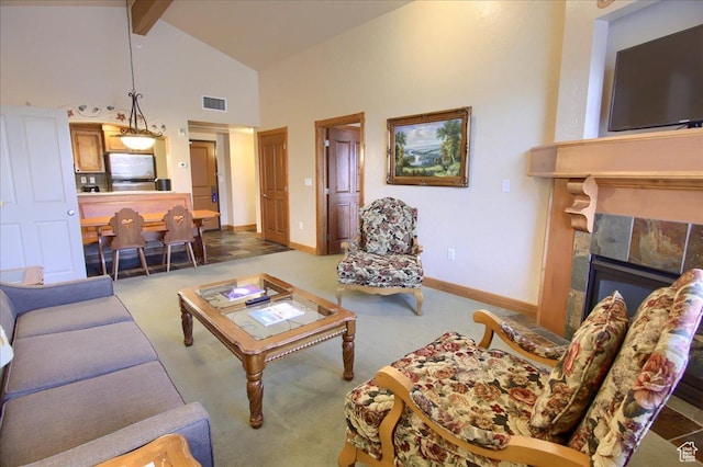carpeted living room featuring beamed ceiling, a stone fireplace, and high vaulted ceiling